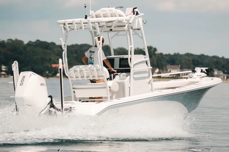 Slide: The Image of 2021 Xplor x24 Andros boat cruising on a calm lake with trees in the background. - 14