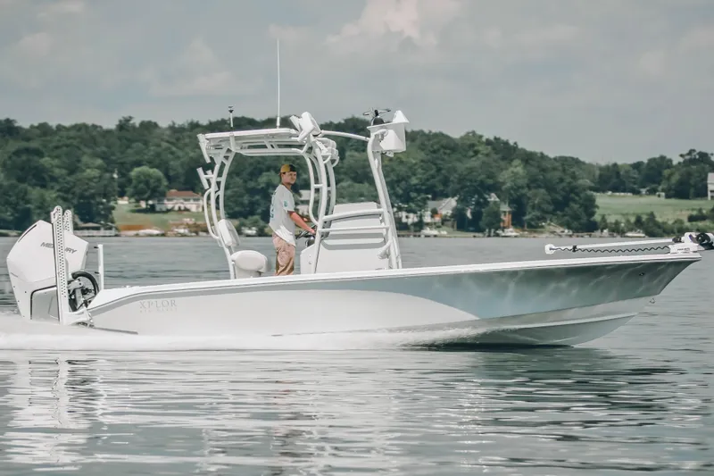 Slide: The Image of 2021 Xplor x24 Andros boat cruising on a calm lake with scenic background. - 15