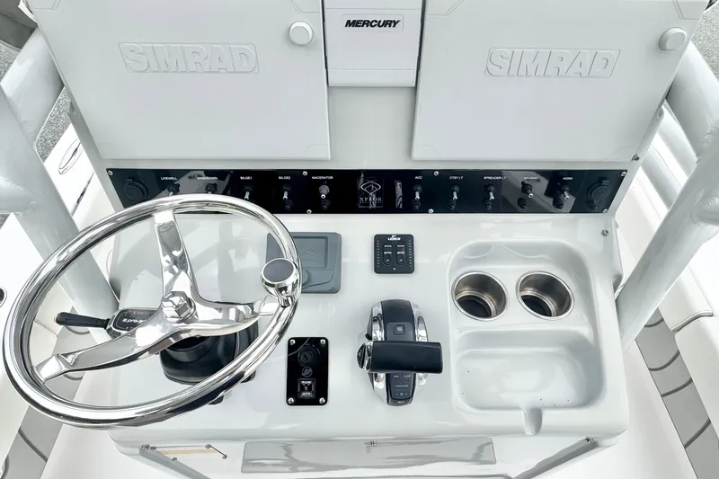 Slide: The Image of 2021 Xplor x24 Andros boat console with steering wheel, controls, and cup holders. - 19