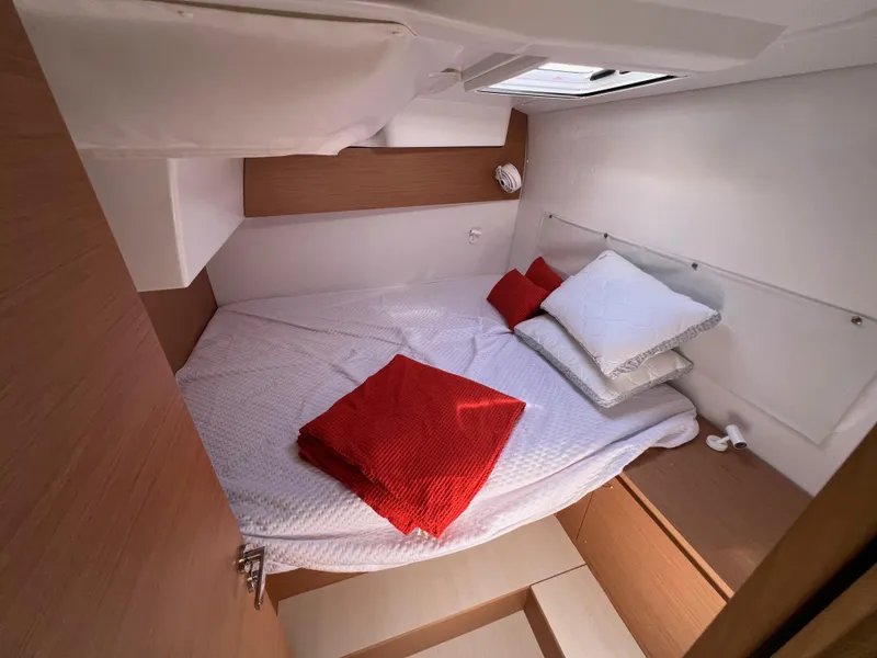 Slide: The Image of Cozy cabin interior of 2022 Excess XCS 11 with bed and red accents. - 7