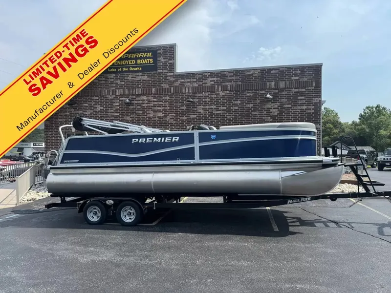 The Image of Premier 220 SUNSCAPE RL 2026 on a trailer in front of a building with a promotional banner. - 1