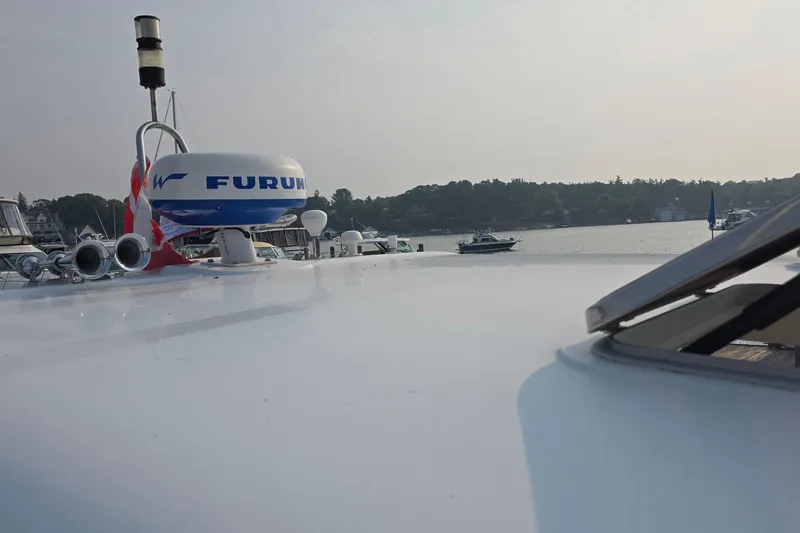 Slide: The Image of 2005 Chris-Craft Roamer 40 yacht with radar, docked by a scenic waterfront. - 12