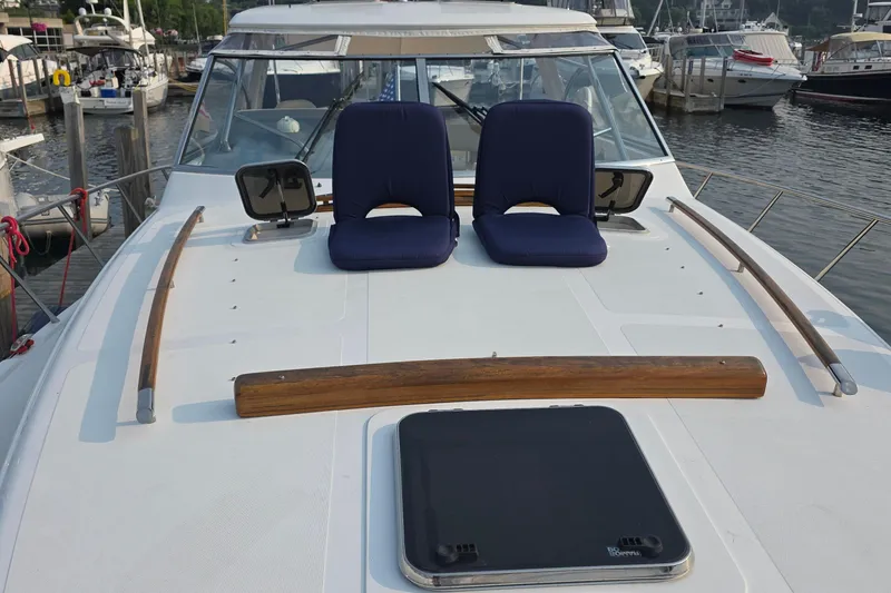 Slide: The Image of 2005 Chris-Craft Roamer 40 yacht deck with blue seats, docked at marina. - 14