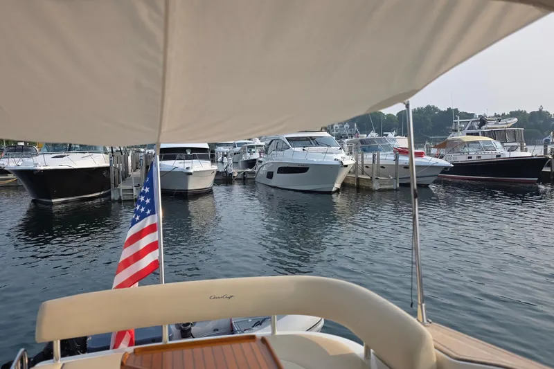 Slide: The Image of 2005 Chris-Craft Roamer 40 yacht docked, view from stern with American flag. - 15