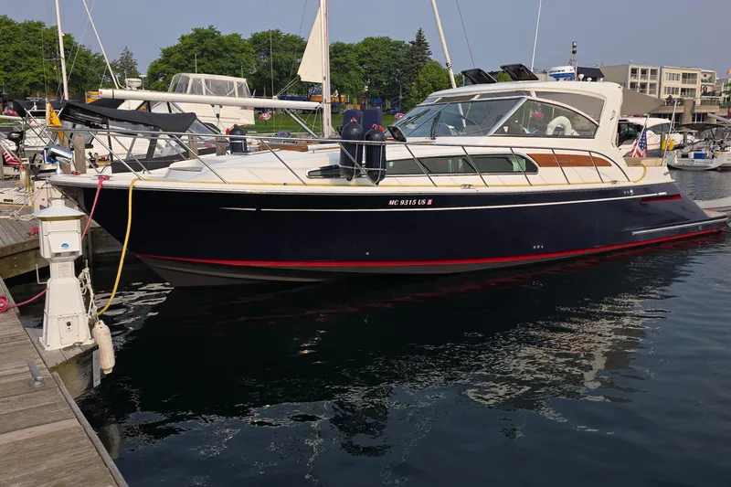 Slide: The Image of 2005 Chris-Craft Roamer 40 yacht on calm water, displaying sleek design and American flag. - 2