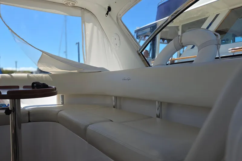 Slide: The Image of Interior of 2005 Chris-Craft Roamer 40 yacht with white seating and wooden table. - 32