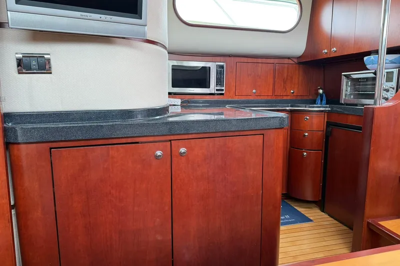 Slide: The Image of Luxurious 2005 Chris-Craft Roamer 40 yacht kitchen with wood cabinetry and modern appliances. - 36