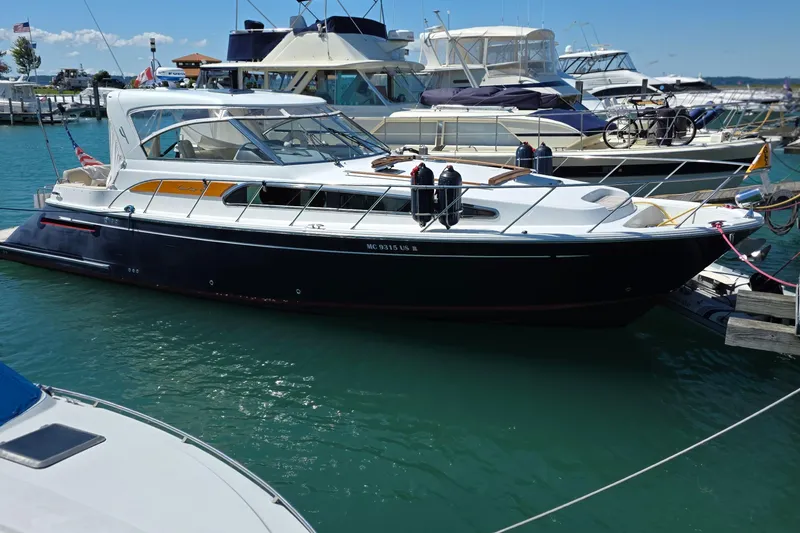 Slide: The Image of 2005 Chris-Craft Roamer 40 yacht docked at marina, sleek design, calm water reflection. - 4