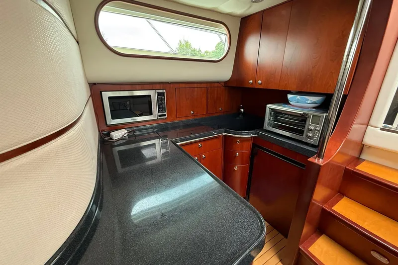 Slide: The Image of Luxurious 2005 Chris-Craft Roamer 40 yacht kitchen with modern appliances and elegant wood cabinetry. - 40