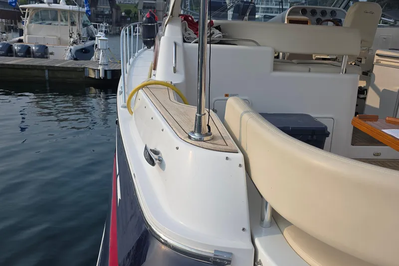 Slide: The Image of 2005 Chris-Craft Roamer 40 yacht docked, showcasing sleek design and luxurious seating. - 53