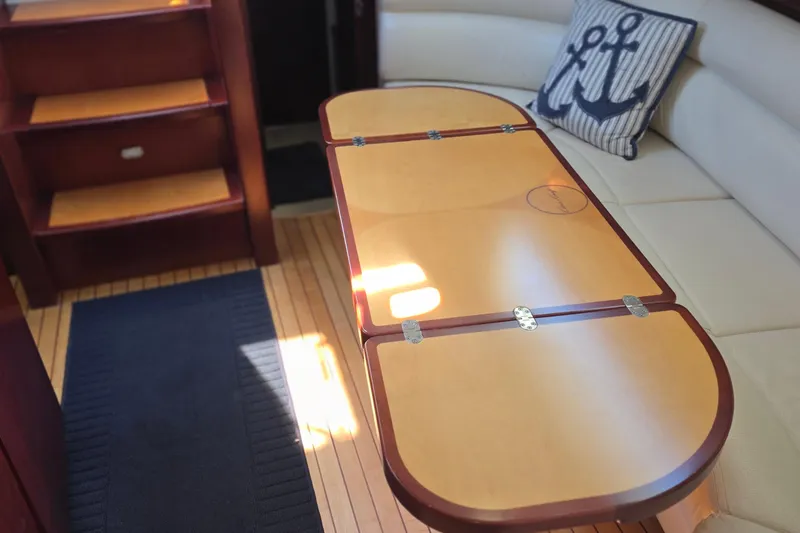 Slide: The Image of Interior of 2005 Chris-Craft Roamer 40 with wooden table and nautical-themed cushion. - 57
