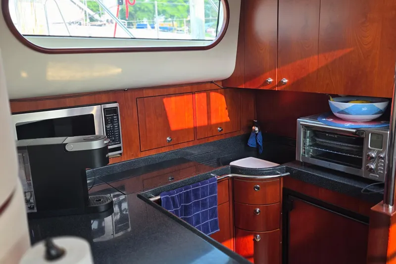 Slide: The Image of Luxurious 2005 Chris-Craft Roamer 40 yacht kitchen with modern appliances and wood cabinetry. - 59