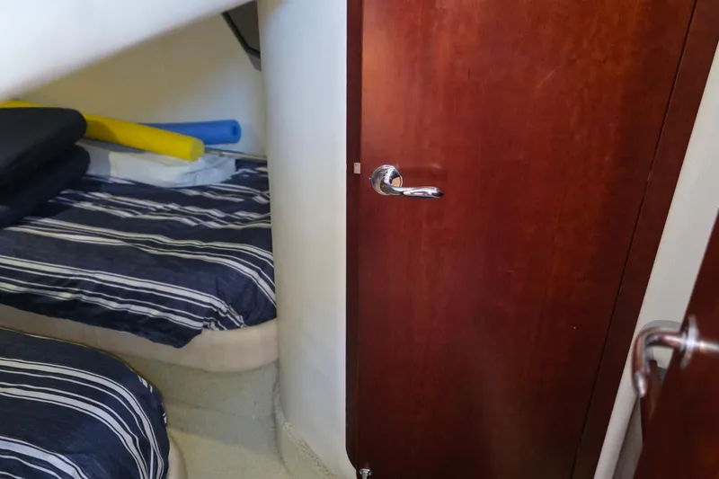 Slide: The Image of Interior cabin of 2005 Chris-Craft Roamer 40 with striped bedding and wooden door. - 71