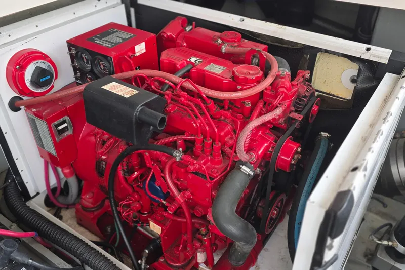 Slide: The Image of Engine compartment of 2005 Chris-Craft Roamer 40, featuring a vibrant red marine engine. - 75