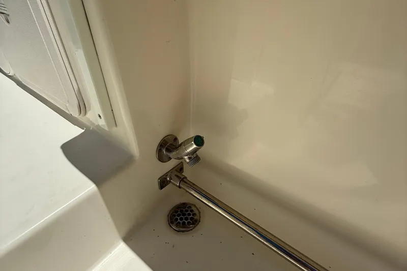 Slide: The Image of 2015 Cobia 296 Center Console boat interior detail with drain and faucet. - 13