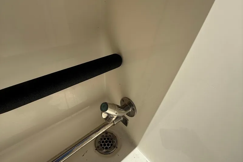 Slide: The Image of Interior detail of a 2015 Cobia 296 Center Console boat, featuring a drain and handle. - 14