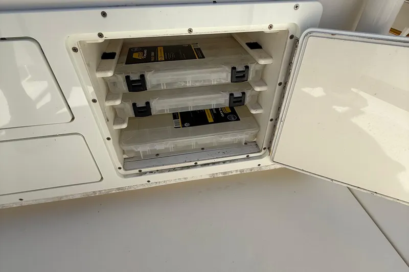 Slide: The Image of Storage compartment with tackle boxes on a 2015 Cobia 296 Center Console boat. - 18
