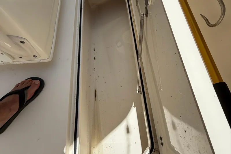 Slide: The Image of Open storage compartment on 2015 Cobia 296 Center Console boat deck. - 19