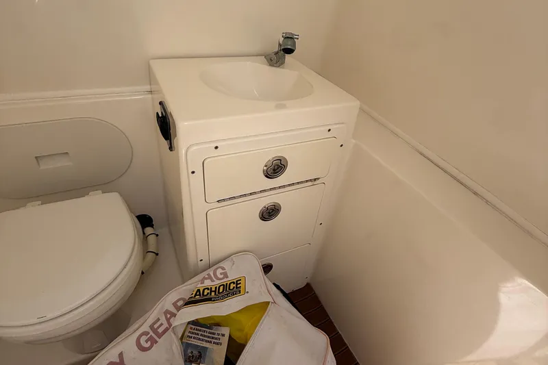 Slide: The Image of 2015 Cobia 296 Center Console boat bathroom with sink and storage. - 22