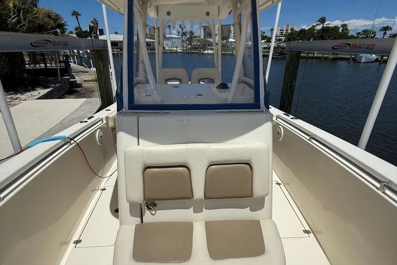 Slide: The Image of 2015 Cobia 296 Center Console boat interior with seating, docked by the water. - 24