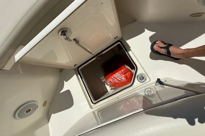 Slide: The Image of Open storage compartment on 2015 Cobia 296 Center Console boat, showing interior contents. - 27