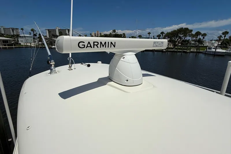 Slide: The Image of 2015 Cobia 296 Center Console with Garmin xHD2 radar on deck, docked by waterfront. - 30