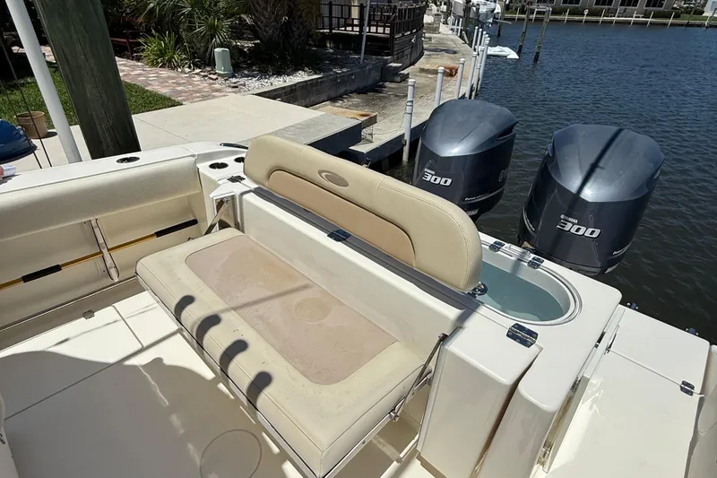 Slide: The Image of 2015 Cobia 296 Center Console boat with twin Yamaha 300 engines docked by the water. - 9