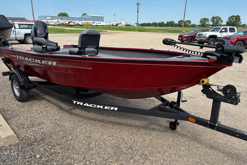 Slide: The Image of 2025 Tracker Super Guide V-16 T boat in red, parked on a trailer in a lot. - 28