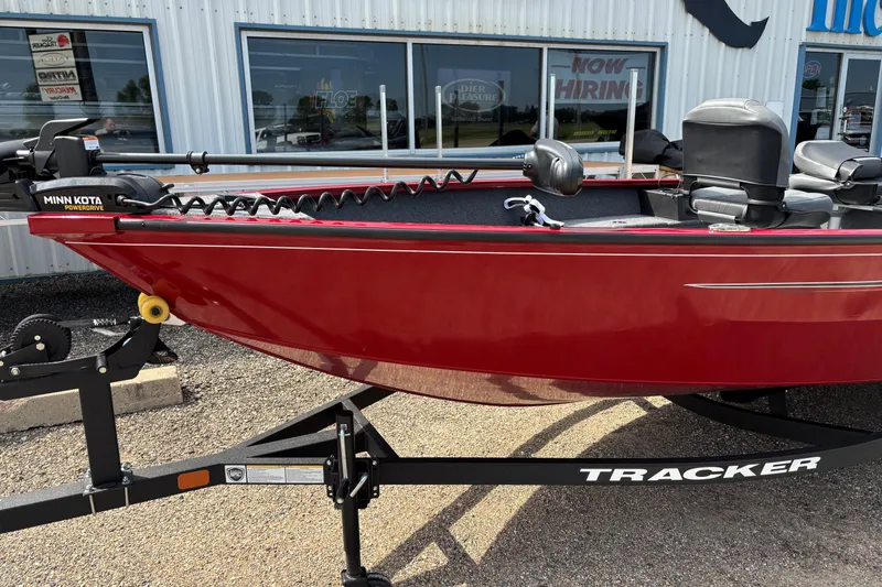 Slide: The Image of Red 2025 Tracker Super Guide V-16 T boat on trailer, parked outside dealership. - 29