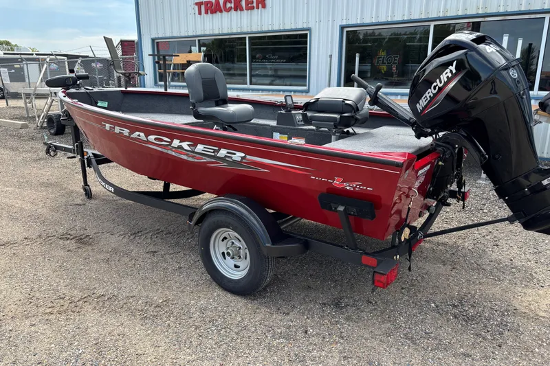 Slide: The Image of Red 2025 Tracker Super Guide V-16 T boat with Mercury engine, parked outside dealership. - 32