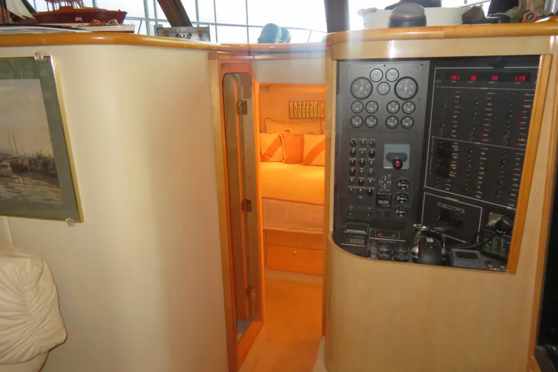 Slide: The Image of Interior of 2000 Bluewater Yachts 5800, featuring control panel and cozy cabin. - 12