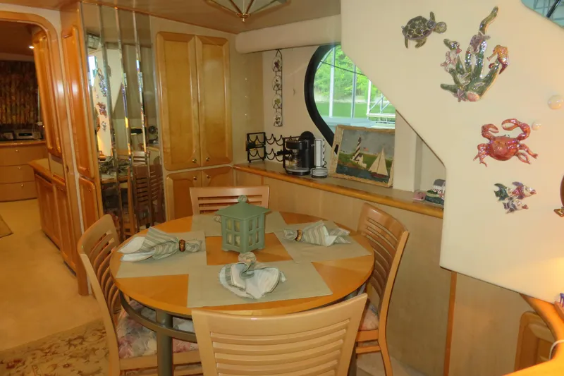 Slide: The Image of Dining area inside 2000 Bluewater Yachts 5800, featuring nautical decor and wooden cabinetry. - 16