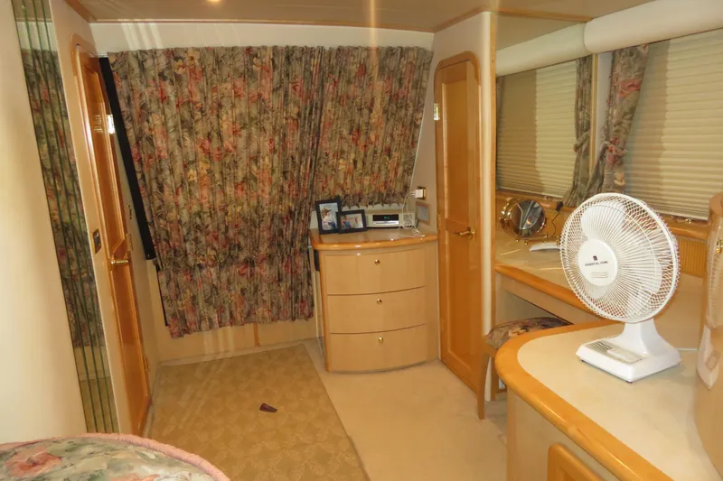 Slide: The Image of Interior of 2000 Bluewater Yachts 5800 with floral curtains and wooden cabinetry. - 19