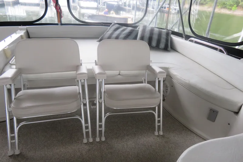 Slide: The Image of Interior of 2000 Bluewater Yachts 5800 with white seating and striped cushions. - 8