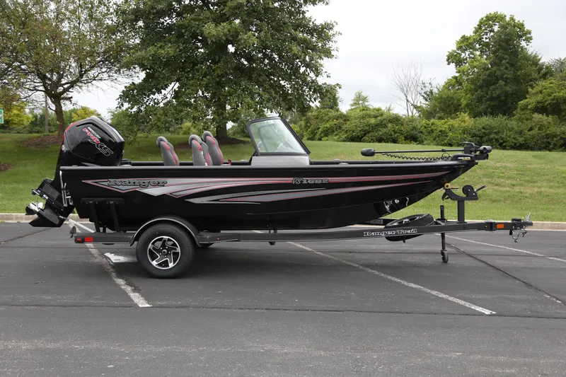 Slide: The Image of 2024 Ranger VS1682SC Angler boat on trailer, parked outdoors with trees in background. - 1