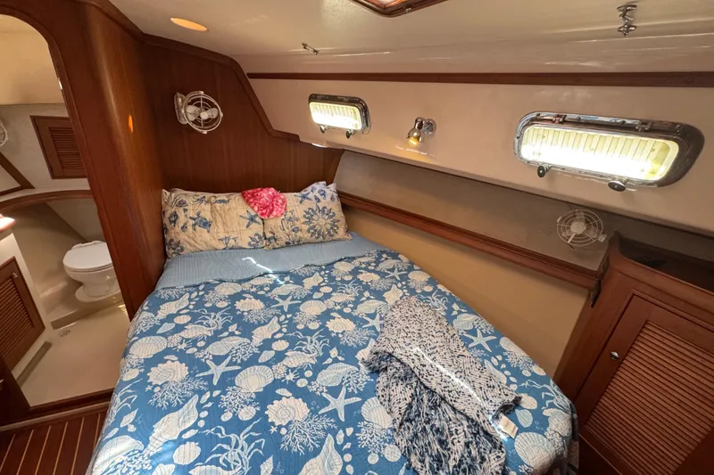 Slide: The Image of Cozy cabin interior of 2004 Island Packet 420 sailboat with nautical-themed bedding. - 10