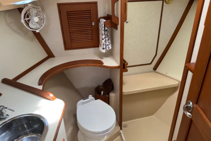 Slide: The Image of 2004 Island Packet 420 yacht bathroom with sink, toilet, and shower area. - 15