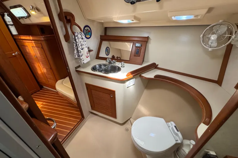 Slide: The Image of 2004 Island Packet 420 yacht bathroom with sink, toilet, and wooden accents. - 16