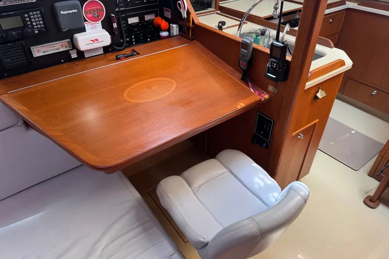 Slide: The Image of Navigation station in 2004 Island Packet 420 yacht with wooden desk and communication equipment. - 19
