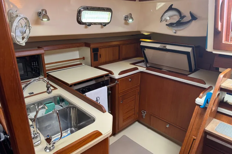 Slide: The Image of Interior of 2004 Island Packet 420 yacht kitchen with wooden cabinetry and stainless steel sink. - 21