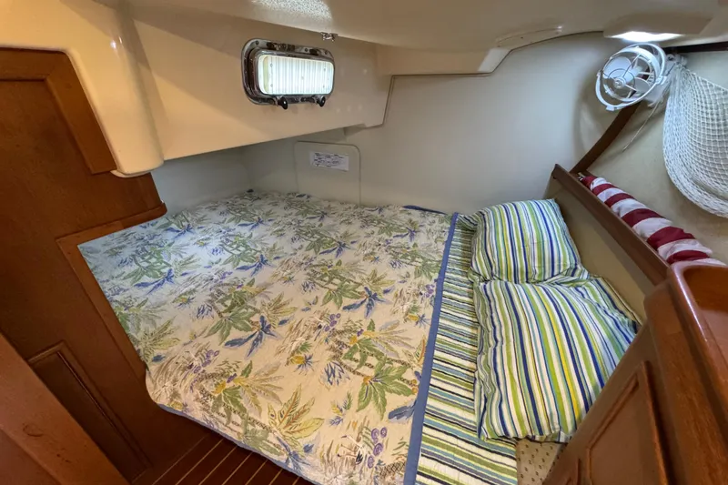 Slide: The Image of Cozy cabin interior of 2004 Island Packet 420 sailboat with floral bedding and striped pillows. - 26