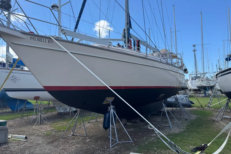Slide: The Image of 2004 Island Packet 420 sailboat on stands in a boatyard under clear blue sky. - 31