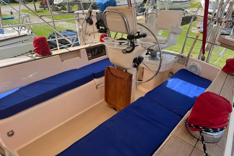 Slide: The Image of 2004 Island Packet 420 sailboat cockpit with blue cushions and steering wheel. - 35