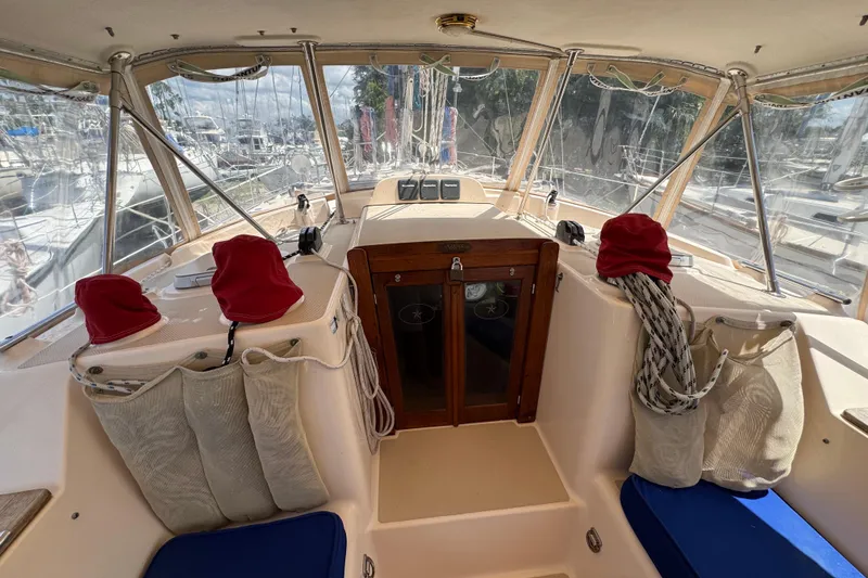 Slide: The Image of 2004 Island Packet 420 yacht cockpit with red covers and blue cushions. - 43