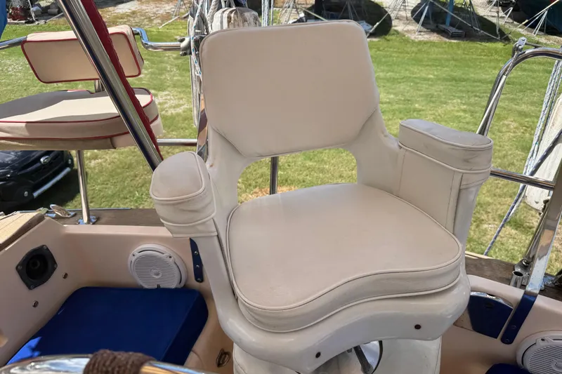 Slide: The Image of Captain's chair on 2004 Island Packet 420 sailboat, featuring white upholstery and armrests. - 45