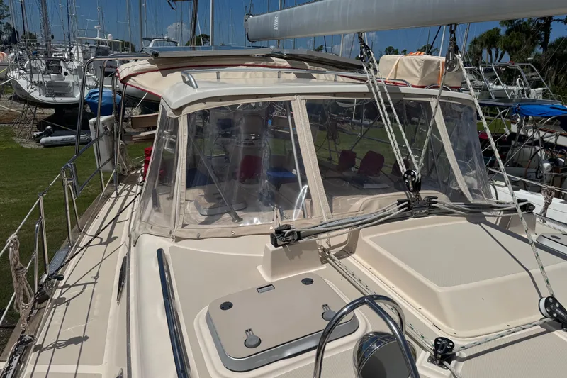 Slide: The Image of 2004 Island Packet 420 sailboat with clear cockpit enclosure, docked among other boats. - 54