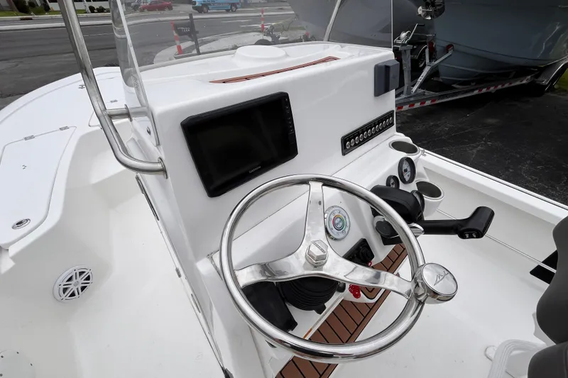 Slide: The Image of 2022 Tidewater 2110 Bay Max boat dashboard with steering wheel and navigation controls. - 14