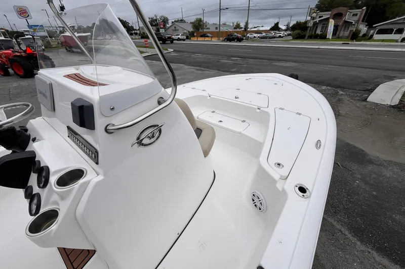 Slide: The Image of 2022 Tidewater 2110 Bay Max boat, white interior, parked near a road. - 9