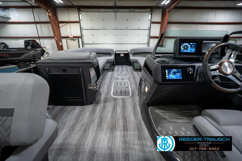 Slide: The Image of Indoor showroom displaying various pontoon boats, including a 2026 Bennington 26 MSB model. - 19