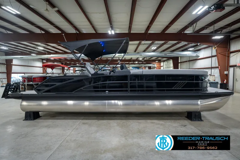 Slide: The Image of 2026 Bennington 26 MSB pontoon boat in showroom with illuminated lights. - 6